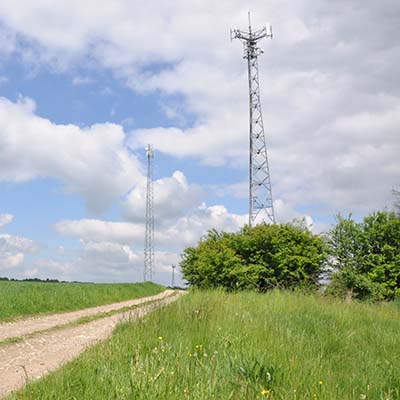 View of telecommunication tower in a field 